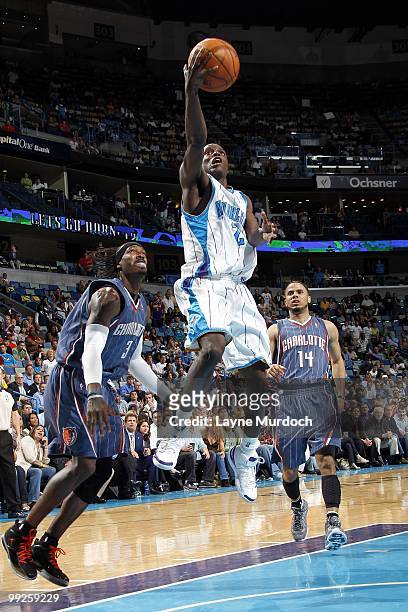 Darren Collison of the New Orleans Hornets goes to the basket against Gerald Wallace and D.J. Augustin of the Charlotte Bobcats during the game at...