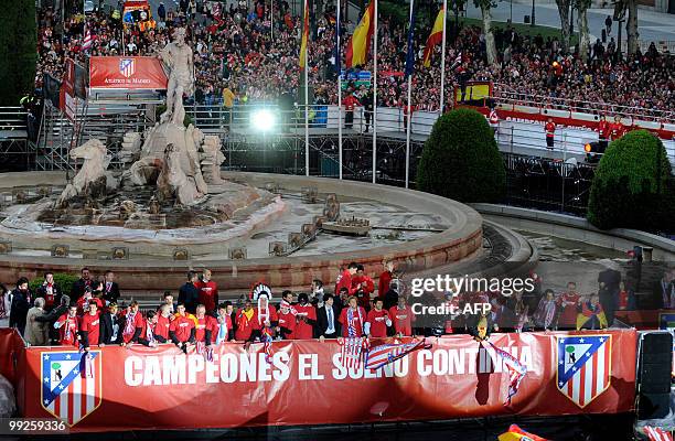 Supporters of Atletico de Madrid's football players celebrate at the Neptune fountain in the center of Madrid on May 13, 2010 with Atletico Madrid...