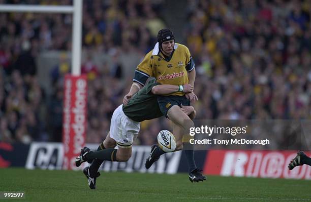 Butch James, #10 Flyhalf for the South African Springboks tackles Stephen Larkham, Flyhalf for the Australian Wallabies during the Tri-Nations Rugby...