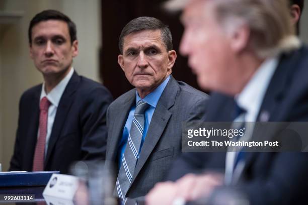 National Security Adviser Mike Flynn listens to President Trump during a listening session with cyber security experts in the Roosevelt Room the...