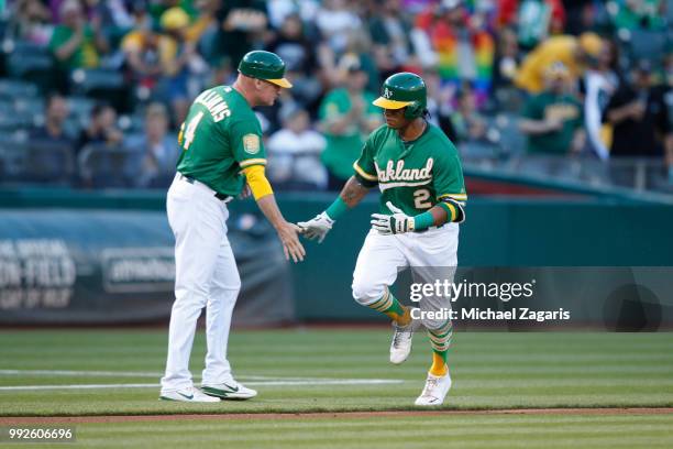 Khris Davis of the Oakland Athletics is congratulated by Third Base Coach Matt Williams while running the bases after hitting a home run during the...