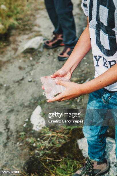 closeup image of boy´s handholding big piece of ice from lake, jostedal,norway - verwaltungsbezirk sogn og fjordane stock-fotos und bilder