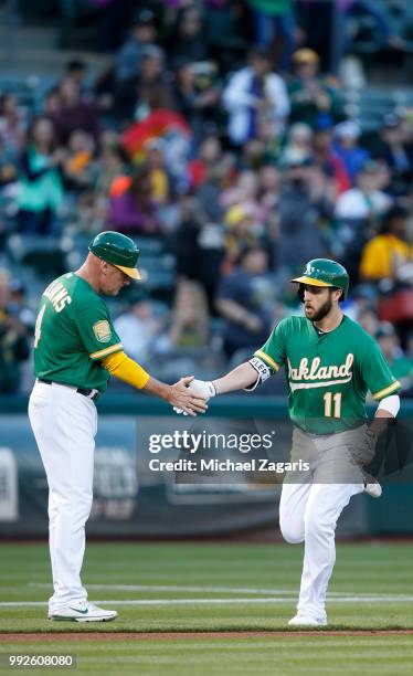 Dustin Fowler of the Oakland Athletics is congratulated by Third Base Coach Matt Williams while running the bases after hitting a home run during the...
