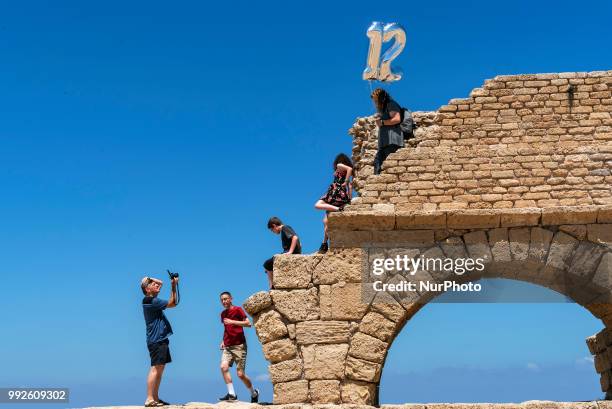 Tourists walk amidst ancient ruins in the port of Caesarea, Israel on June 24, 2018. Caesarea National Park is known for its Roman amphitheater,...