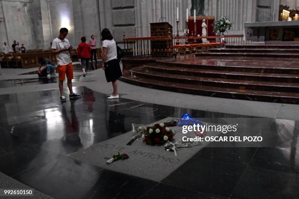 People stand next to the grave of Jose Antonio Primo de Rivera, founder of the Spanish right-wing movement La Falange at the Valle de los Caidos , a...