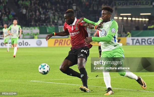 Wolfsburg's Divock Origi and Hannover's Salif Sane vying for the ball during the DFB Cup soccer match between VfL Wolfsburg and Hannover 96 in the...