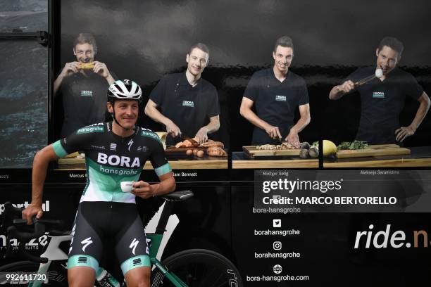 Marcus Germany's Marcus Burghardt drinks a cup of coffe prior to departing for a training session of Germany's Bora-Hansgrohe cycling team on July 6,...