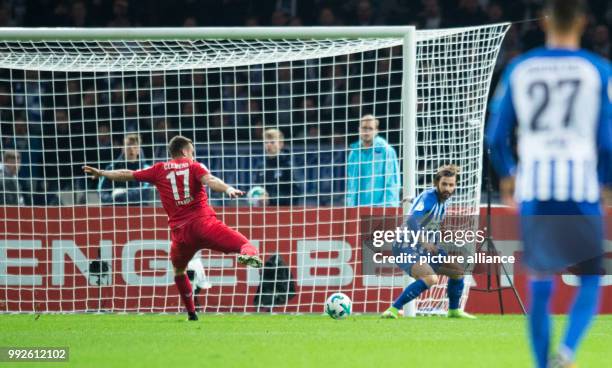 Cologne's Christian Clemens scores his side's third goal against Hertha's goalkeeper Marvin Plattenhardt during the German DFB Pokal football match...