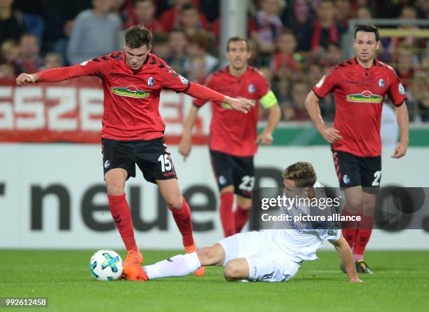 Freiburg's Pascal Stenzel and Dresden's Jannik Muller vying for the ball during the DFB Cup soccer match between SC Freiburg and Dynamo Dresden in...