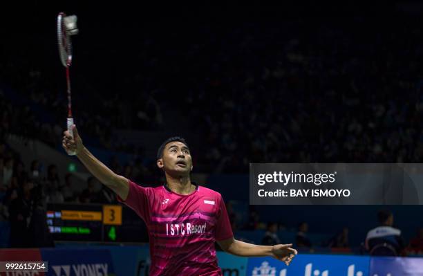 Tommy Sugiarto of Indonesia hits a return against Kento Momota of Japan during their men's singles quarter-final match at the Indonesia Open...