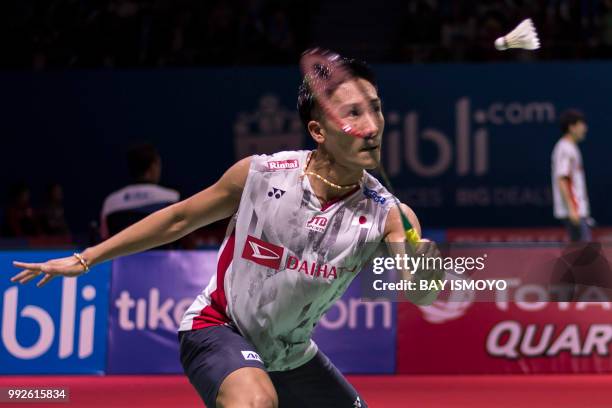 Kento Momota of Japan hits a return against Tommy Sugiarto of Indonesia during their men's singles quarter-final match at the Indonesia Open...