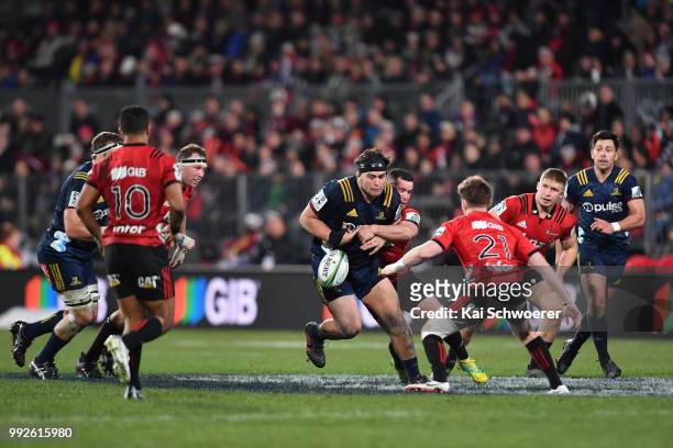 Tyrel Lomax of the Highlanders is tackled by Ryan Crotty of the Crusaders during the round 18 Super Rugby match between the Crusaders and the...