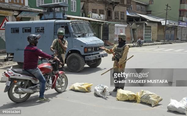 Indian paramilitary troopers talk to a motorcyclist on a blocked road outside the Jamia Masjid mosque after authorities imposed restrictions in...