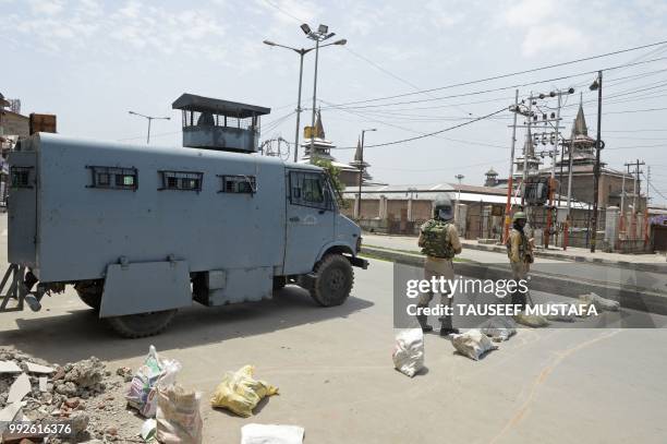 Indian paramilitary troopers stand guard on a blocked road as they stands guard outside the Jamia Masjid mosque after authorities imposed...