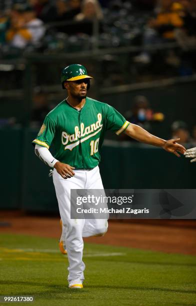 Marcus Semien of the Oakland Athletics is congratulated at the dugout after scoring during the game against the Kansas City Royals at the Oakland...