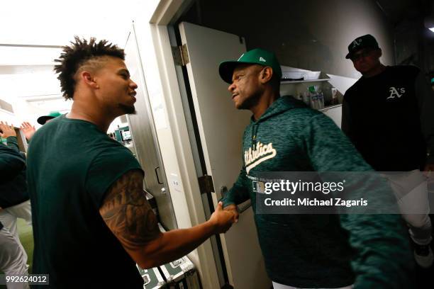 Frankie Montas and Special Assistant to the President Rickey Henderson of the Oakland Athletics celebrate in the clubhouse following the game against...