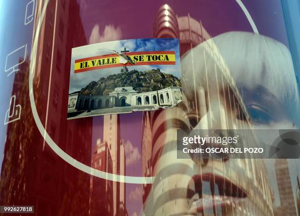 Sticker reading 'Do not touch The Valley' and depecting a picture of Valle de los Caidos is pictured in a street of Madrid on July 02, 2018. -...