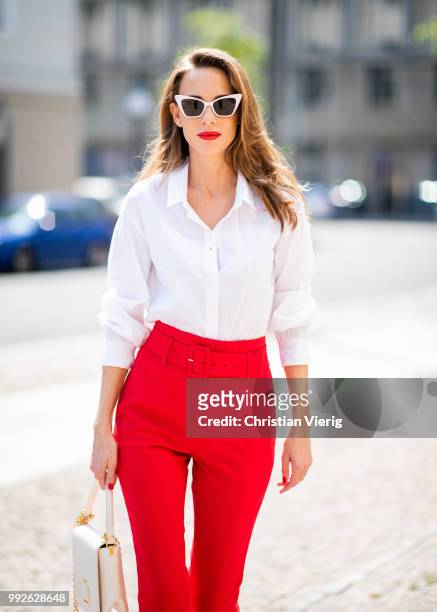 Alexandra Lapp wearing a red suit combination in bright red with high waist pants with an attached belt and a slim cut blazer with an integrated...