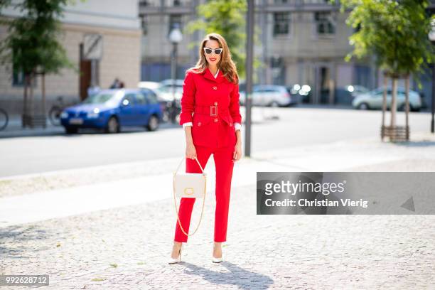 Alexandra Lapp wearing a red suit combination in bright red with high waist pants with an attached belt and a slim cut blazer with an integrated...