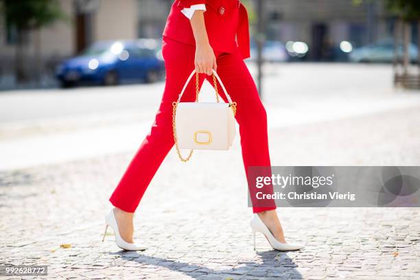 Alexandra Lapp wearing a red suit combination in bright red with high waist pants with an attached belt and a slim cut blazer with an integrated...