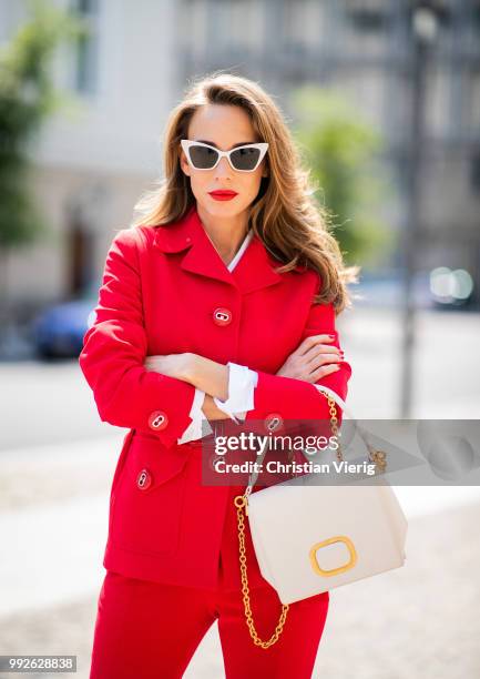 Alexandra Lapp wearing a red suit combination in bright red with high waist pants with an attached belt and a slim cut blazer with an integrated...