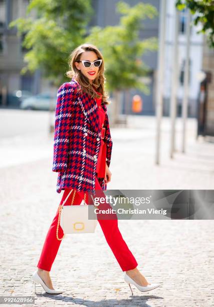 Alexandra Lapp wearing a red suit combination in bright red with high waist pants with an attached belt and a slim cut blazer with an integrated...