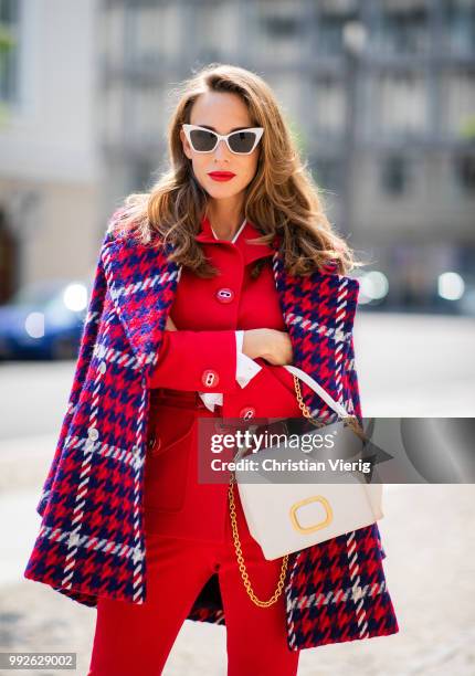 Alexandra Lapp wearing a red suit combination in bright red with high waist pants with an attached belt and a slim cut blazer with an integrated...