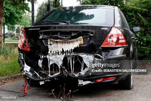 View of a fire damaged vehicle in the Belleville neighbourhood of Nantes on July 6 following another night of violence in the western French city. -...