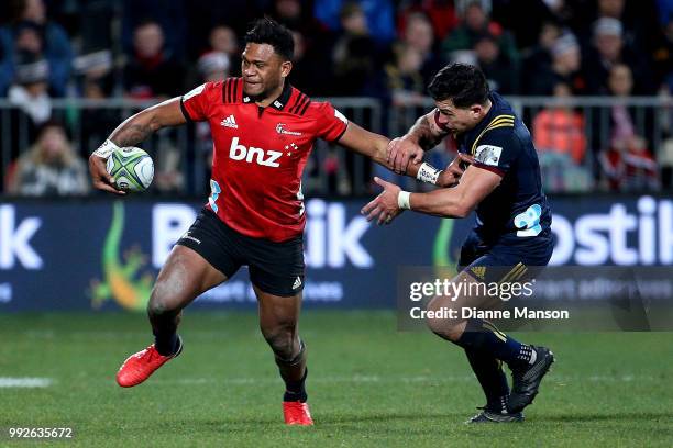 Seta Tamanivalu of the Crusaders fends off Rob Thompson of the Highlanders during the round 18 Super Rugby match between the Crusaders and the...