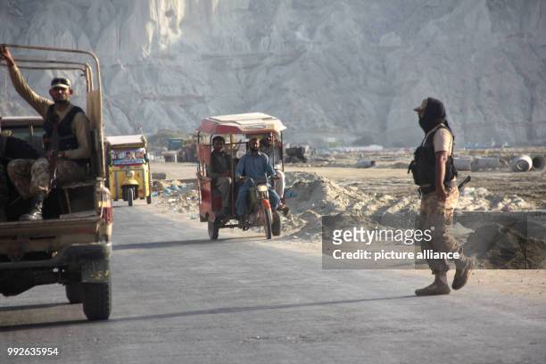 Pakistani soldiers stopping traffic in order to control acccess to a heavily protected visitors' colony in the port town of Gwadar in southern...