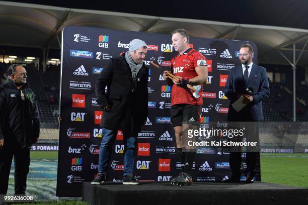 Wyatt Crockett of the Crusaders receives a taiaha, a traditional Maori weapon, from former All Black and team mate Corey Flynn after his 200th Super...