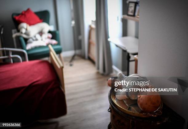 Picture taken on July 5, 2018 shows a baby doll in a bedroom's resident in an establishment of accommodation for dependent elderly in Paris.