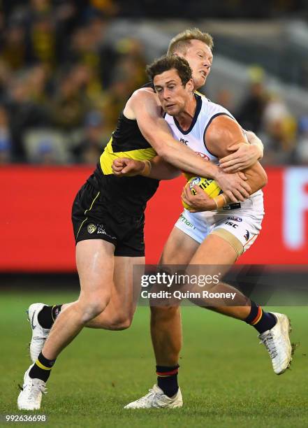 Kyle Hartigan of the Crows is tackled by Jack Riewoldt of the Tigers during the round 16 AFL match between the Richmond Tigers and the Adelaide Crows...