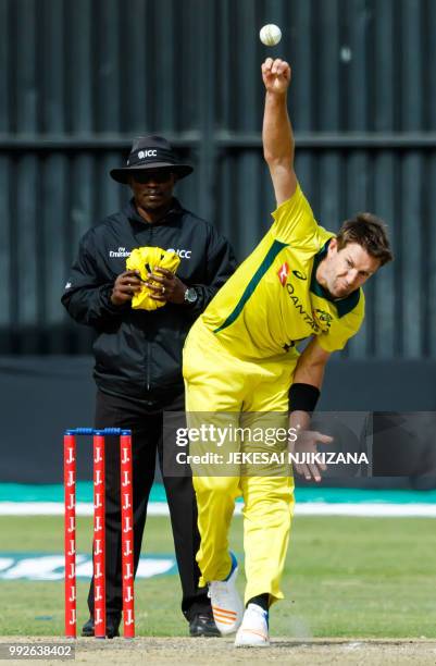 Australia's bowler Andrew Tye delivers the ball past umpire Jeremiah Matibiri during the sixth T20 cricket match between Australia and host nation...