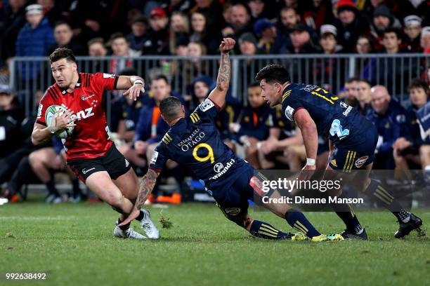 David Havili of the Crusaders slips through the tackled of Aaron Smith of the Highlanders during the round 18 Super Rugby match between the Crusaders...