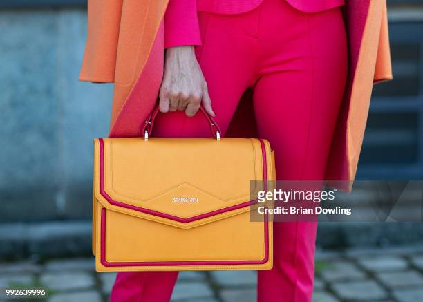 Alexandra Lapp, bag detail, poses during the Marc Cain Street Style shooting at WECC on July 3, 2018 in Berlin, Germany.