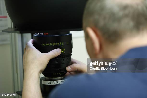An employee carries out aperture quality checks on a 75 mm master prime camera lens, manufactured by Cal Zeiss AG, at the ARRI AG cinematic and...