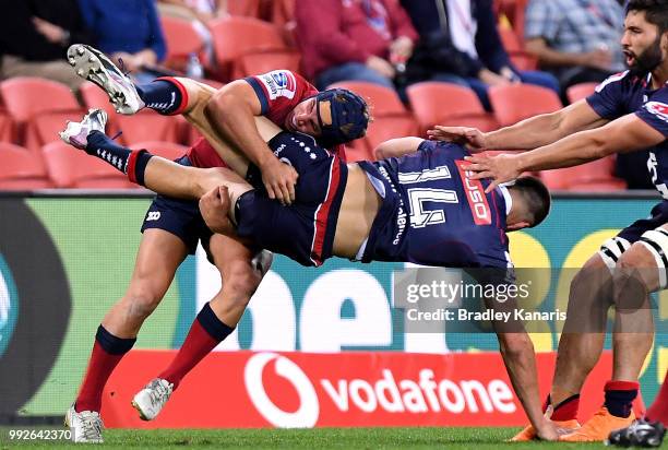 Jack Maddocks of the Rebels is picked up in the tackle by Hamish Stewart of the Reds during the round 18 Super Rugby match between the Reds and the...