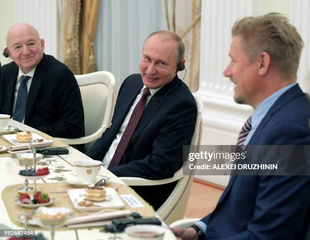 Russian President Vladimir Putin speaks with Danish footballer Peter Schmeichel as First Vice President of the Russian Football Union Nikita Simonyan...