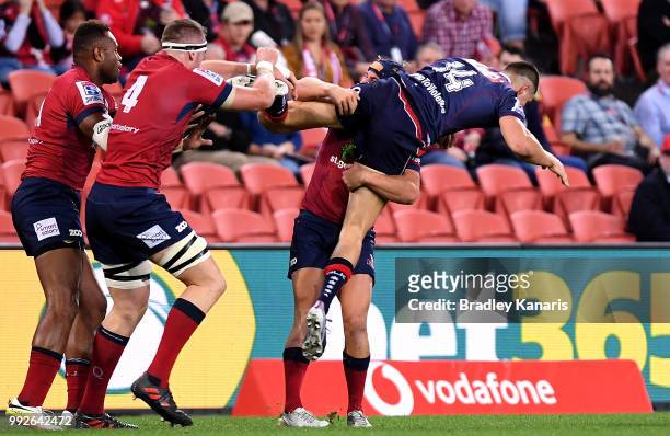 Jack Maddocks of the Rebels is picked up in the tackle by Hamish Stewart of the Reds during the round 18 Super Rugby match between the Reds and the...