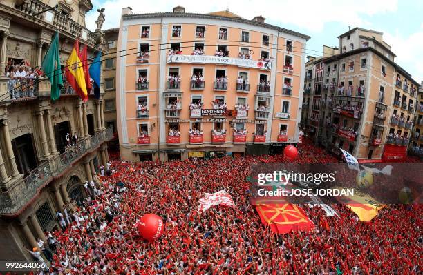 Participants hold banners in support of Basque prisoners as they celebrate the 'Chupinazo' to mark the kickoff at noon sharp of the San Fermin...