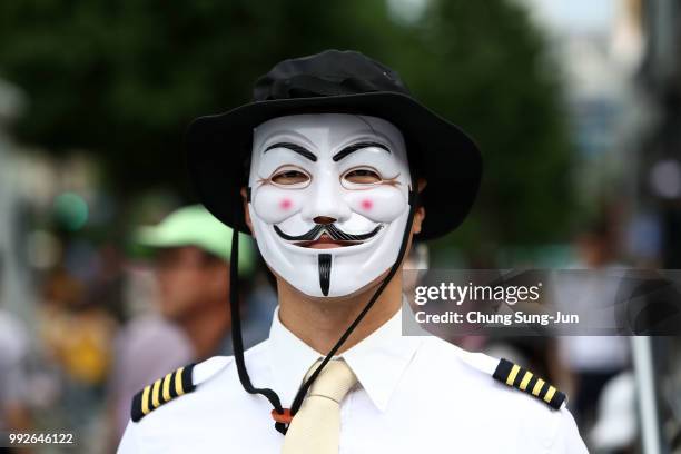 Korean Air pilot wearing Guy Fawkes mask, attends a rally to call for resignation of Hanjin Group Chairman Cho Yang-ho on July 5, 2018 in Seoul,...