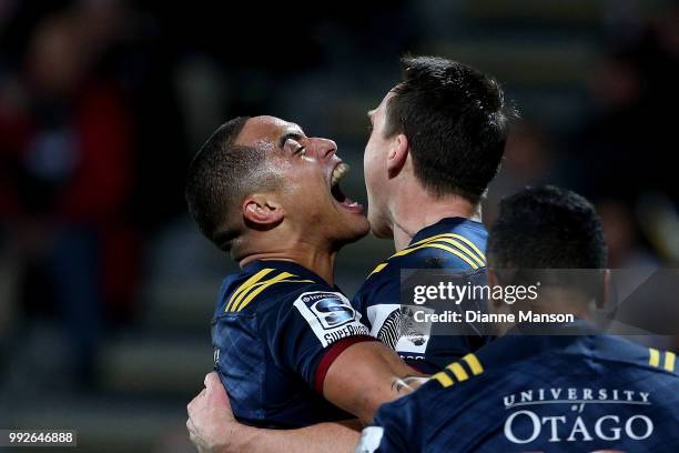 Ben Smith of the Highlanders celebrates his try with team-mate Aaron Smith during the round 18 Super Rugby match between the Crusaders and the...