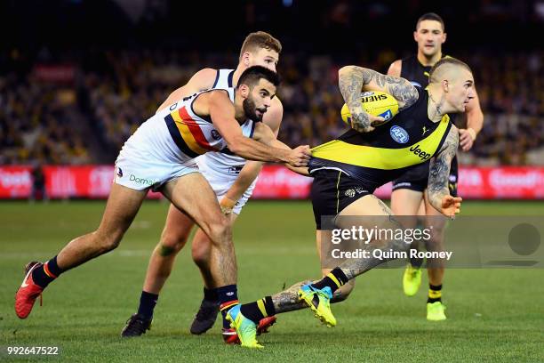 Dustin Martin of the Tigers is tackled by Wayne Milera of the Crows during the round 16 AFL match between the Richmond Tigers and the Adelaide Crows...