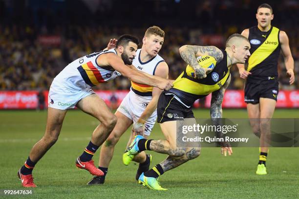 Dustin Martin of the Tigers is tackled by Wayne Milera of the Crows during the round 16 AFL match between the Richmond Tigers and the Adelaide Crows...