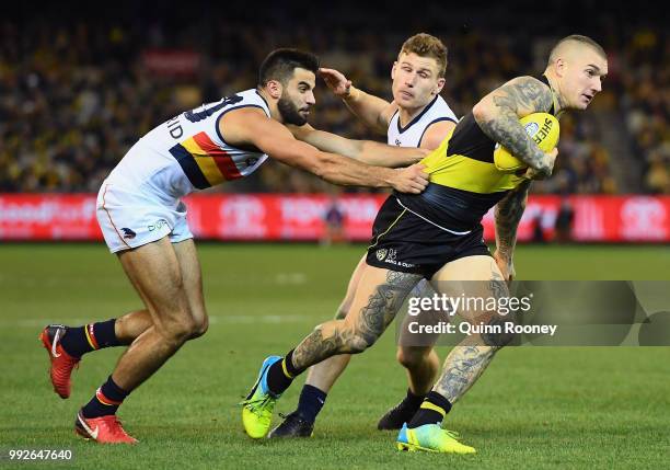 Dustin Martin of the Tigers is tackled by Wayne Milera of the Crows during the round 16 AFL match between the Richmond Tigers and the Adelaide Crows...