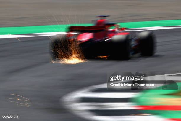 Sparks fly behind Sebastian Vettel of Germany driving the Scuderia Ferrari SF71H on track during practice for the Formula One Grand Prix of Great...