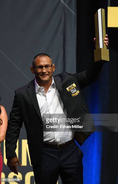 Former mixed martial artist Dan Henderson holds a trophy onstage after his 2011 fight against Mauricio "Shogun" Rua in UFC 139 was inducted into the...