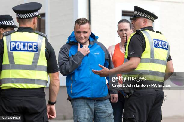 Police talk to members of the public outside the Greenock Sheriff Court after people were heard shouting insults at the van containing the 16 year...