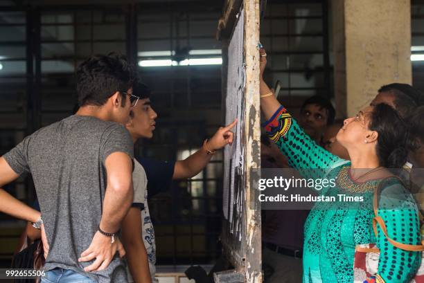 Students and parents check the first merit list of FYJC at Ruia College, Matunga, on July 5, 2018 in Mumbai, India. The first merit list for...